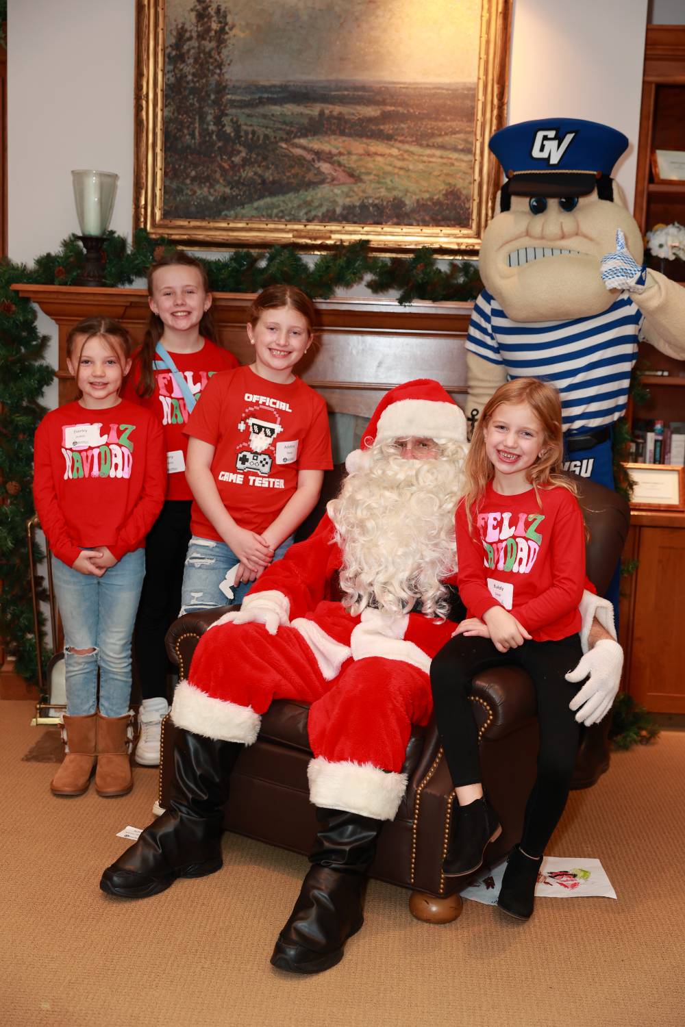 Four girls sitting with Santa & Louie at the Holiday Brunch.